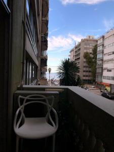 a white chair sitting on the balcony of a building at Departamento Pocitos con anfitrión in Montevideo +4 photos