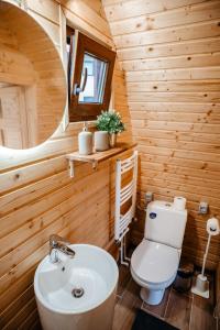 a wooden bathroom with a toilet and a sink at Glamp In Style Pods Resort in Bran