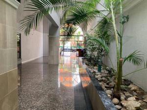 a hallway with a palm tree in a building at Apartamento Empresarial La Carolina zona comercial in Quito