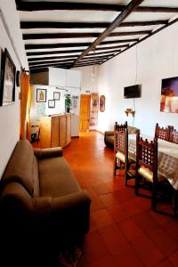Il comprend un salon avec un canapé et des chaises ainsi qu'une cuisine. dans l'établissement Hospedería Villa Lucía, à Villa de Leyva