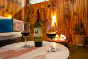 a bottle of wine and two glasses on a table at Loft vista da serra in Serra de São Bento