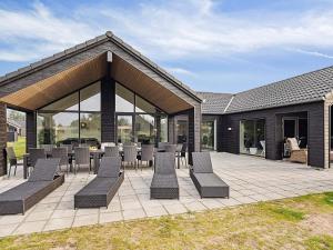 a patio with chairs and tables and a building at Luxury Retreat with Pool - By Traum Ferienwohnungen in Kongsmark