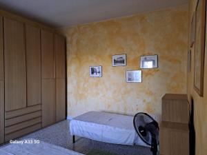 1 dormitorio con 1 cama y cuadros en la pared en Da Nonna Rosa, en Budrio