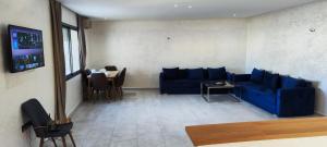 - un salon avec un canapé bleu et une table dans l'établissement La Rose Bleu 3 Chambre Terrasse, à Tanger