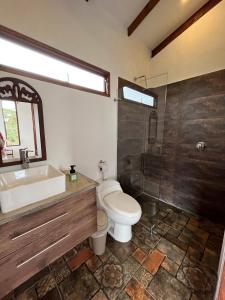 a bathroom with a toilet and a sink and a shower at Despierte con la naturaleza in Cogua