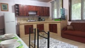 cocina con armarios de madera, mesa y sofá en Complejo Ecoturistico Tamandua, en Drake