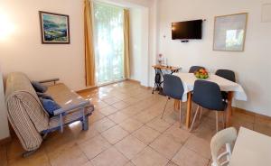 uma sala de estar com um sofá e uma mesa em Apartments Marino em Drvenik