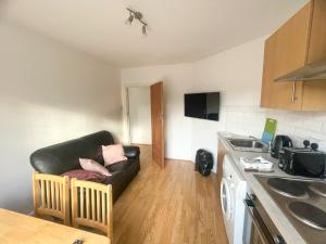 a living room with a couch in a kitchen at Pinner apartments in Pinner