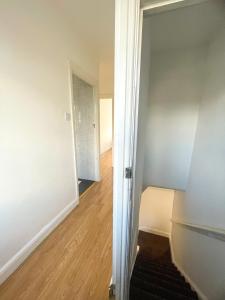an empty room with a door and a hallway at Pinner apartments in Pinner