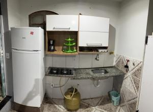uma pequena cozinha com um frigorífico e um lavatório em kitnet em cabo frio 01 em Cabo Frio