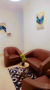 dos sofás de cuero marrón y una mesa en una habitación en Appartement Beau Séjour 1, en Dakar