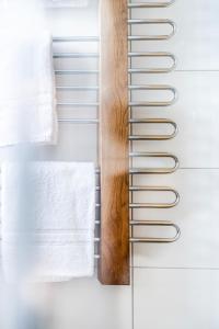 a towel rack in a bathroom with white towels at Berg Aparts Faschina - 05 - b42791 in Fontanella