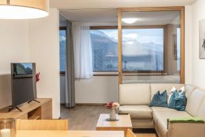 salon z kanapą i telewizorem w obiekcie Berg Aparts Faschina - 03 - b42790 w mieście Fontanella