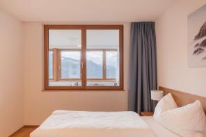 een slaapkamer met een bed en een raam bij Berg Aparts Faschina - 03 - b42790 in Fontanella