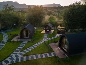 Glamp In Style Pods Resort في برانْ: منظر جوي لمجموعة من الخيام في حقل