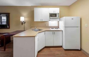 a kitchen with white cabinets and a white refrigerator at Extended Stay America Suites - Orange County - Anaheim Convention Center in Anaheim