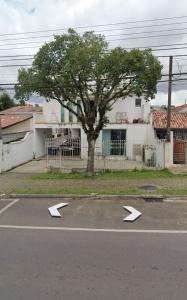 a parking lot with arrow signs in front of a tree at Suíte Hostel Curitiba in Curitiba