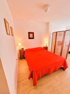 1 dormitorio con 1 cama roja en una habitación en Apartamento cerca a la playa del Cura ! Cura Beach, en Torrevieja