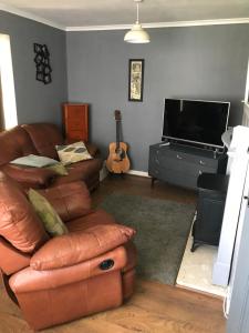 a living room with a couch and a television at Stonyhurst in Chorley