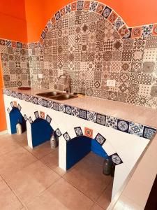 a kitchen with a sink and a tile wall at Villa Tequila - Casa Jalisco in Alta Gracia