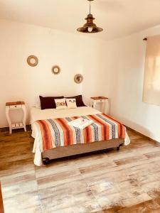 ein Schlafzimmer mit einem Bett mit einer bunten Bettdecke in der Unterkunft Villa Tequila - Casa Jalisco in Alta Gracia