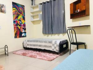 ein Zimmer mit einem Bett und einem Stuhl darin in der Unterkunft Quarto Aconchego em Canaã dos Carajás in Canaã dos Carajás