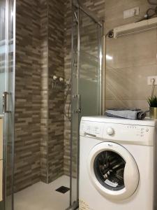 una lavatrice in un bagno con doccia di Green Beach Las Canteras a Las Palmas de Gran Canaria