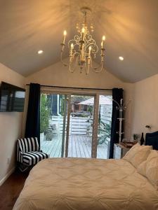 a bedroom with a bed and a chandelier at Adorable 1 bedroom cottage in Forest Hills