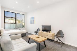 a living room with a couch and a tv at 302 The Residence in Auckland