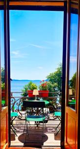 Habitación con vistas a un balcón con mesa y sillas. en Casa Gambusso historical house magnificent Lake View, en Verbania