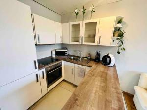a small kitchen with white cabinets and a wooden floor at Auszeit Niedersfeld in Winterberg