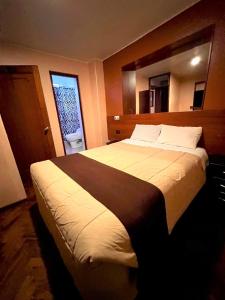 Cama grande en habitación de hotel con ventana en Posada de Belén, en Arequipa