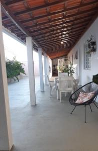 un patio con sillas, mesa y techo en Casa aconchegante em Guapé, Lago de Furnas. en Guapé