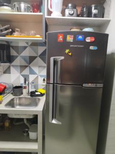 a stainless steel refrigerator in a kitchen with a sink at Taguá life apartamento amplo moderno e encantador in Taguatinga