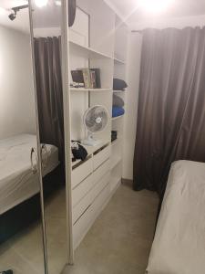 een slaapkamer met een bed en een kast met een ventilator bij Taguá life apartamento amplo moderno e encantador in Taguatinga