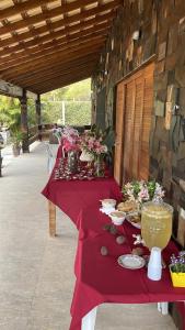 een tafel met een rode tafeldoek en bloemen erop bij Chacara recanto da paz in Mairinque