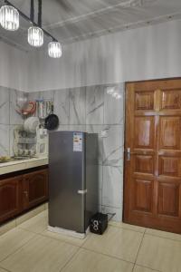 a stainless steel refrigerator in a kitchen next to a door at Meuble Modon Nyalla in Douala