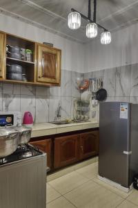 a kitchen with wooden cabinets and a stainless steel refrigerator at Meuble Modon Nyalla in Douala