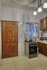 a kitchen with a stove and a wooden door at Meuble Modon Nyalla in Douala
