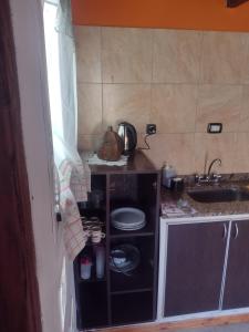 a small kitchen with a stove and a sink at Casa Los Acantilados in Mar del Plata
