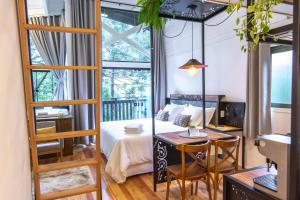 a bedroom with a bed and a table and a desk at Lofts Kayser Haus in Urubici