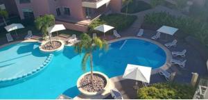 - une vue sur la piscine bordée de chaises et de parasols dans l'établissement Nouvel appartement luxueux Riad Garden Marrakech, à Marrakech