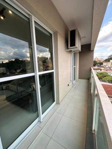 a balcony of a building with large glass windows at Studio Aconchegante e Completo in Ribeirão Preto