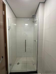 a shower with a glass door in a bathroom at Studio Aconchegante e Completo in Ribeirão Preto