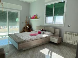 a bedroom with a bed with a teddy bear on it at Villa Begdour à 30Mints de Tanger in Tangier