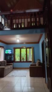 a living room with two couches and a tv at Complejo Ecoturistico Tamandua in Drake