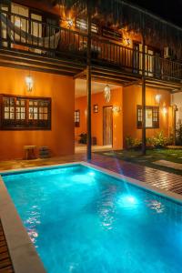 a swimming pool in front of a house at night at Pousada Casa Joana Trancoso in Trancoso