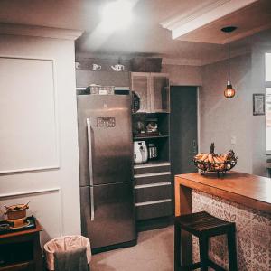 a kitchen with a stainless steel refrigerator and a counter at Suítes Apoena in Arraial do Cabo