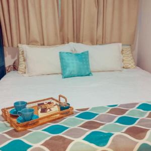 a bed with a tray of food on it at Suítes Apoena in Arraial do Cabo