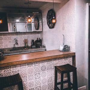 a kitchen with a bar with a counter and two stools at Suítes Apoena in Arraial do Cabo